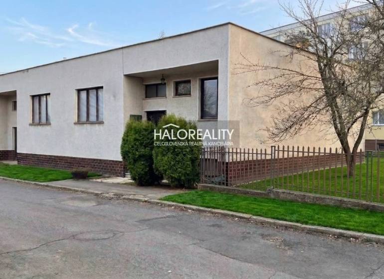 Családi ház Poltáron előkerttel, kerítéssel és gondozott gyepfelülettel egy csendes utcában.