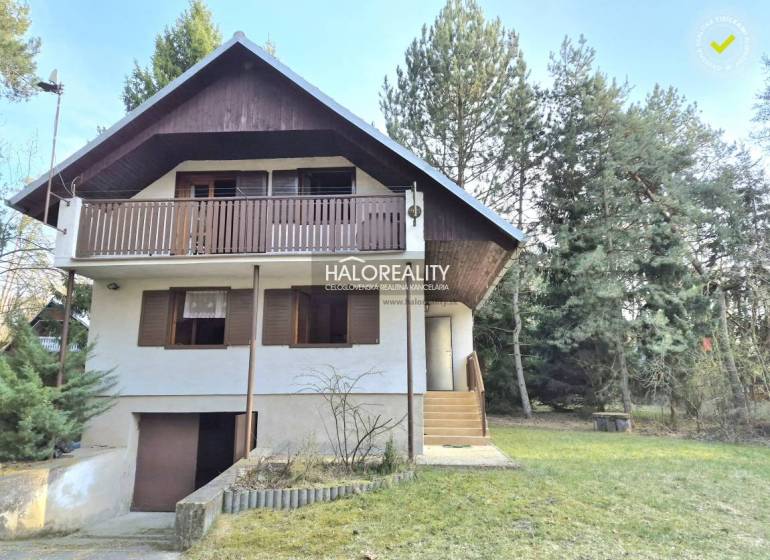 Házikó Borsky Svätý Jurban, zölddel és fákkal körülvéve, fa erkéllyel.