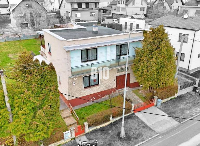 Családi ház Martinban lapos tetővel, kerttel és környező házakkal.