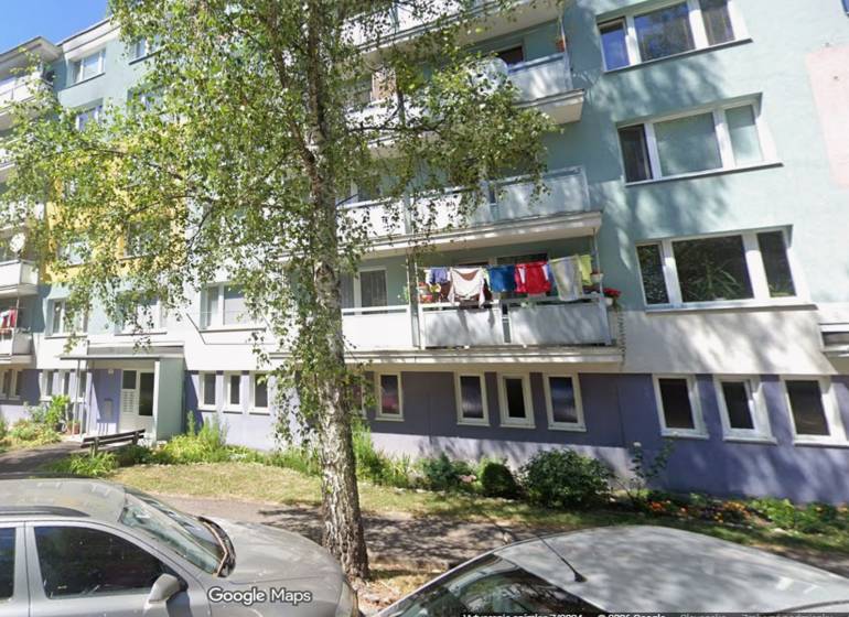 A Beskydská 9-es szám alatti lakóház Besztercebányán zölddel és egy nővel elöl.