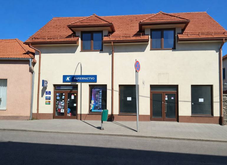 Kereskedelmi helyiségek a Krupina Obchodná utcáján ferde tetővel és kirakatokkal.