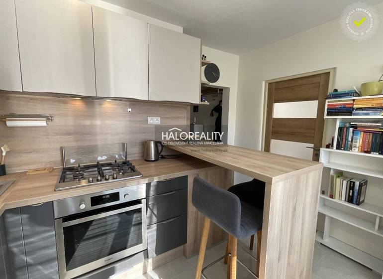 Egyszobás lakás konyhája konyhapulttal és háztartási gépekkel.