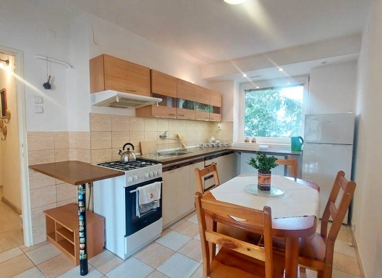 Konyha konyhabútorral és étkezőasztallal egy kétszobás lakásban.