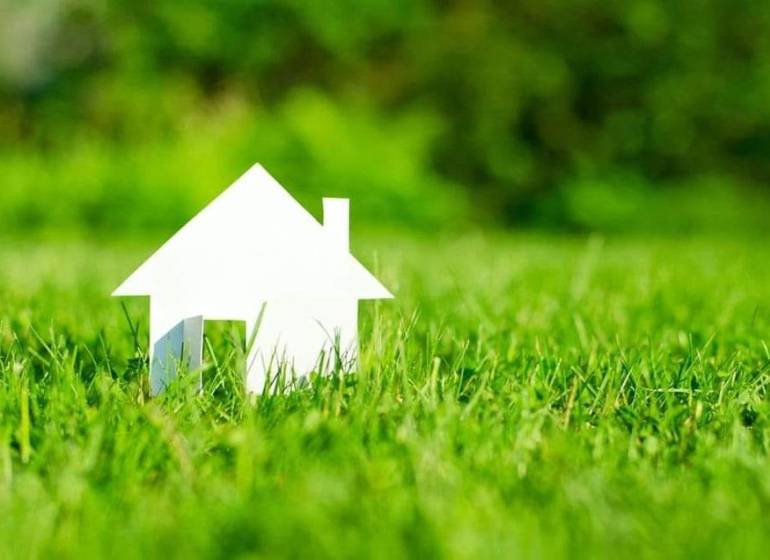 Fehér házmodell zöld fűvön Tešedíkovo-ban, telkek - lakóövezet.