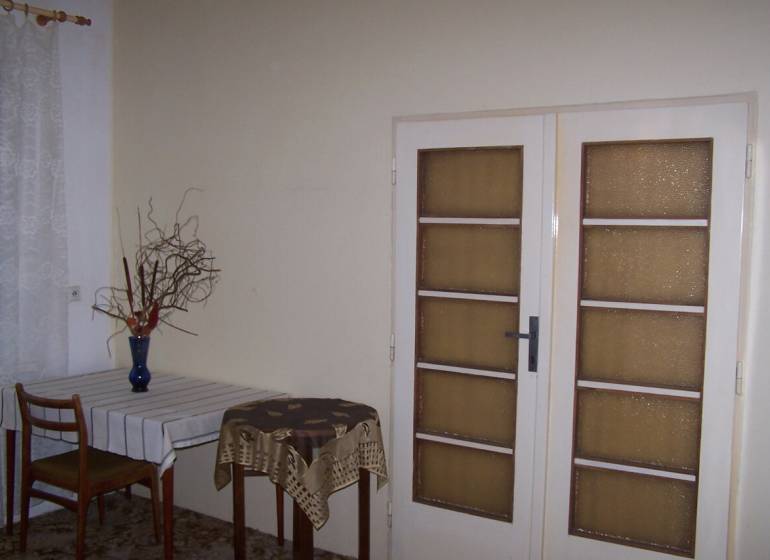 2 szobás lakás belső tere étkezőasztallal és üvegajtókkal.