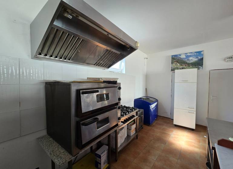 Vendéglátó helyiségek sütővel, páraelszívóval és hűtőszekrénnyel, fa dekorációjú padlóval.