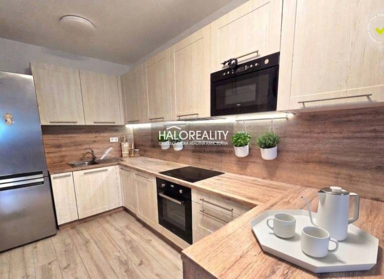 Modern konyha egy kétszobás lakásban fa dekorációval és beépített készülékekkel.