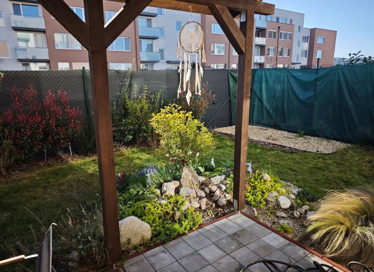 Kert a Jaseňová utcai kétszobás lakásnál Miloslavovban, pergolával és zölddel.