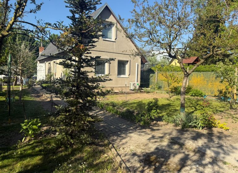 Házikó Sekulén előkerttel, fákkal és rendezett gyepfelülettel a Sekule utcán.