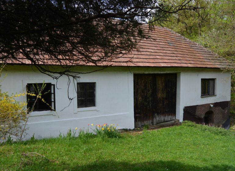 Bukovecben található családi ház ferde tetővel és fa kapukkal.