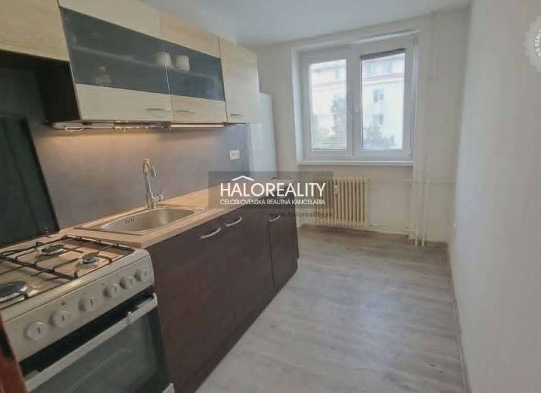 Konyha egy háromszobás lakásban gáztűzhellyel és fa dekorációjú padlóval.