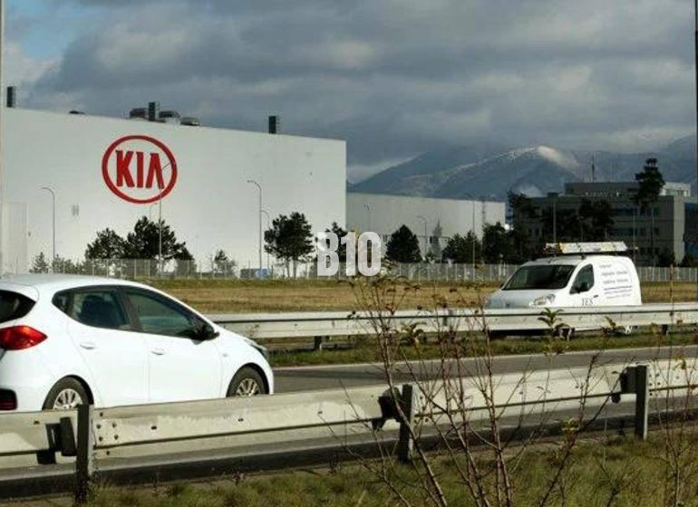 KIA Motors gyár Szlovákiában, autók az autópályán, kereskedelmi telkek a háttérben.