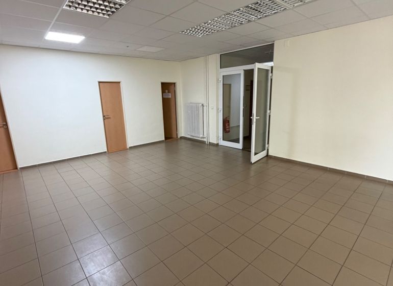 Üres irodák csempézett padlóval és fehér falakkal.