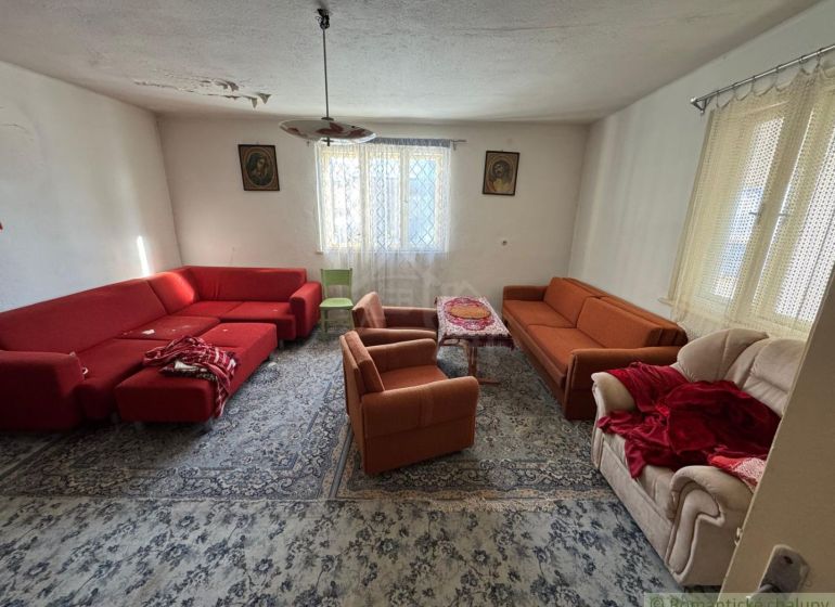 Nappali egy családi házban piros és narancssárga kanapékkal és szőnyeggel.