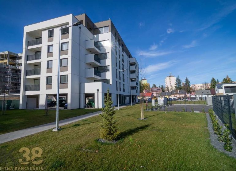 Egy lakóház Poprádon zöld gyepes területtel és a háttérben szomszédos épületekkel.