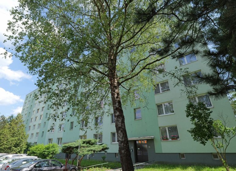Považská Bystrica, Štúrova: Panelház fákkal és az utcán parkoló autókkal körülvéve.