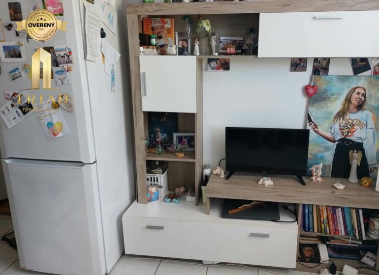 Nappali egy egyszobás lakásban fehér bútorokkal és dekorációkkal.