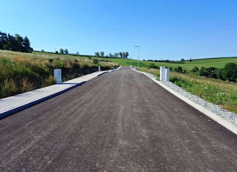 Üres út a zöld mezők között Záboríban, telkek - lakóövezet.