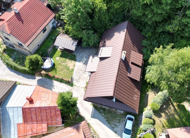 Légi felvétel egy házról Špania Dolinában, Besztercebányán, zölddel körülvéve.