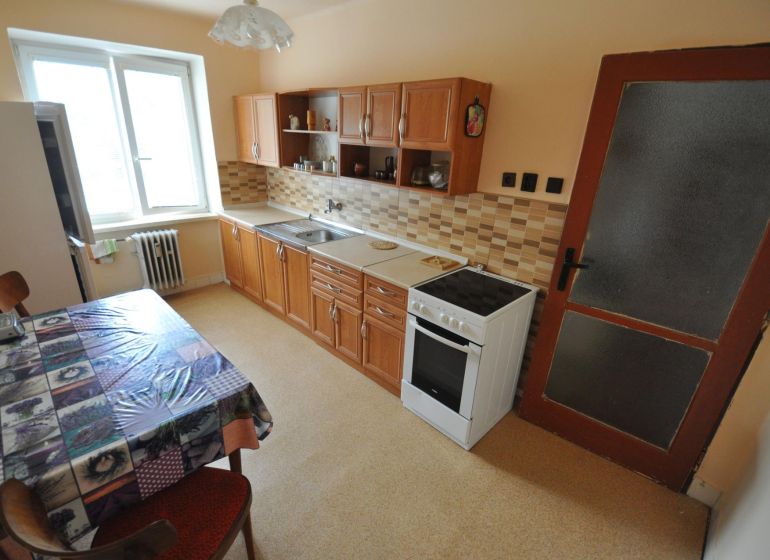 A kétszobás lakás konyhája étkezőasztallal, konyhapulttal és elektromos tűzhellyel.