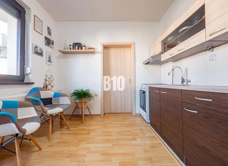 Konyha egy egyszobás lakásban fa dekor padlóval és modern bútorokkal.