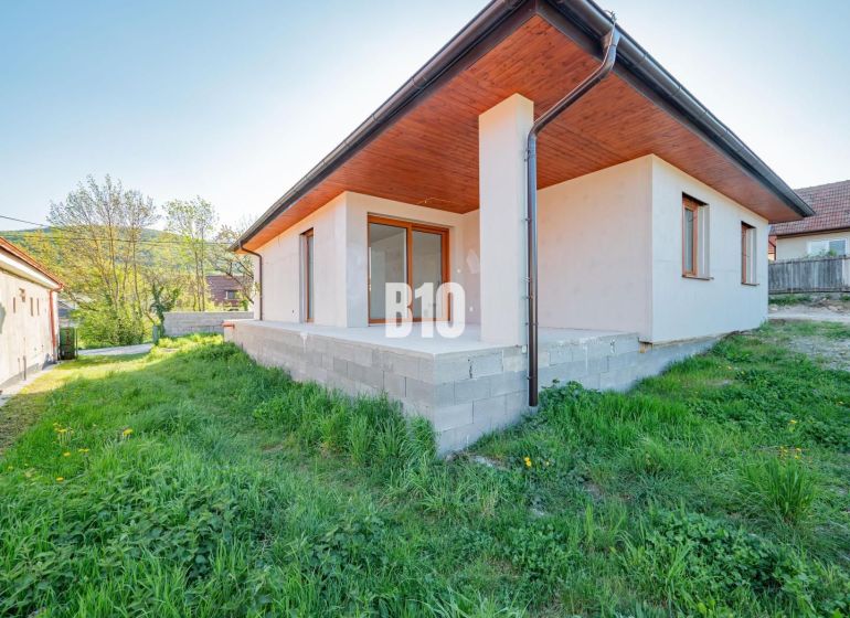 Családi ház Nyitrán beton terasszal és zöld gyepes kerttel.