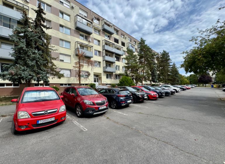 Lakóház melletti parkoló Topoľčanyban az egyszobás lakások lakói számára.