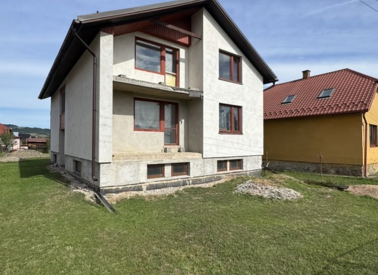 Családi ház Plavnicán zöld gyepes udvarral és részben befejezett homlokzattal.