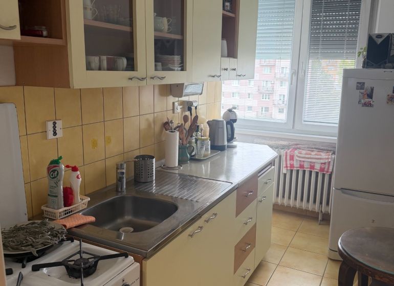 Konyha egy kétszobás lakásban konyhabútorral és háztartási gépekkel.