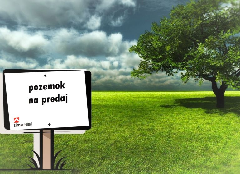 A tábla földterület eladását hirdeti, egy zöld gyep látható a fa mellett.