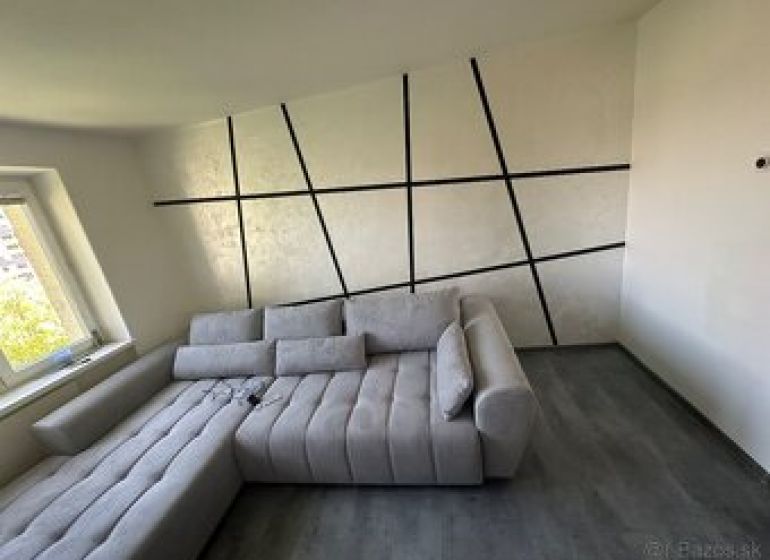 2 szobás lakás belső tere kényelmes kanapéval és fa dekorációjú padlóval.