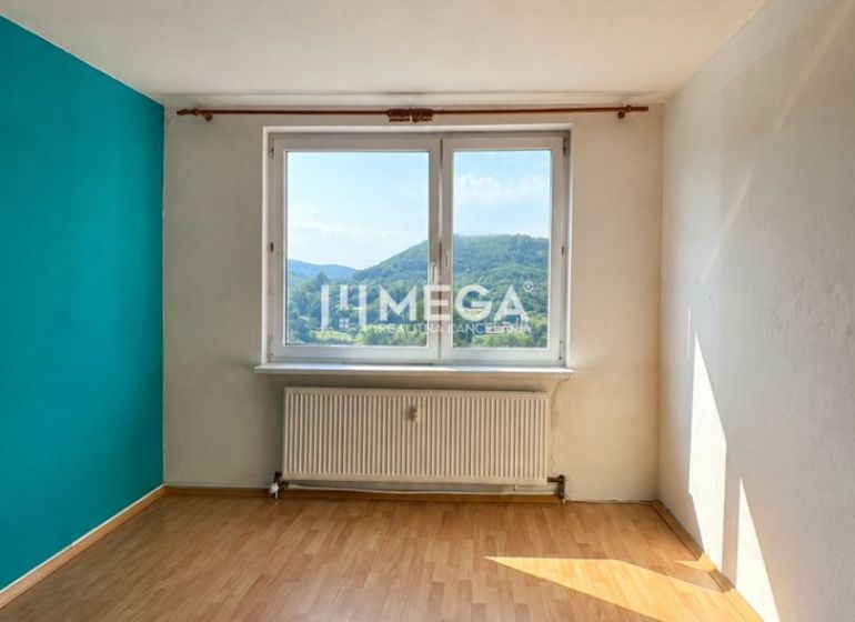Szoba egy háromszobás lakásban, fa dekorációjú padlóval és kilátással a tájra.