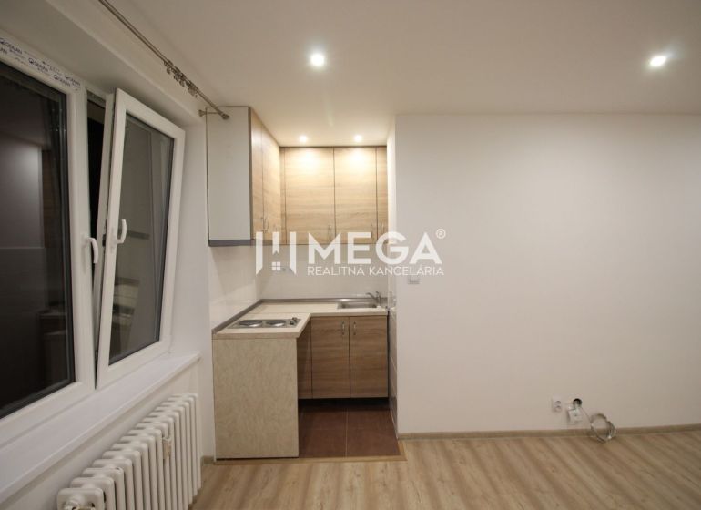 Konyha egy üdülő apartmanban konyhabútorral és fa dekorációjú padlóval.