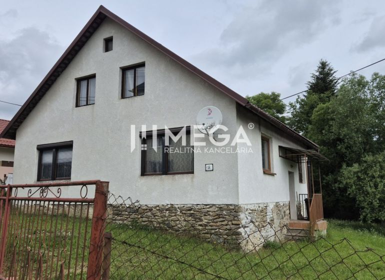 Családi ház Zbojban kőalappal és kerttel, zölddel körülvéve.
