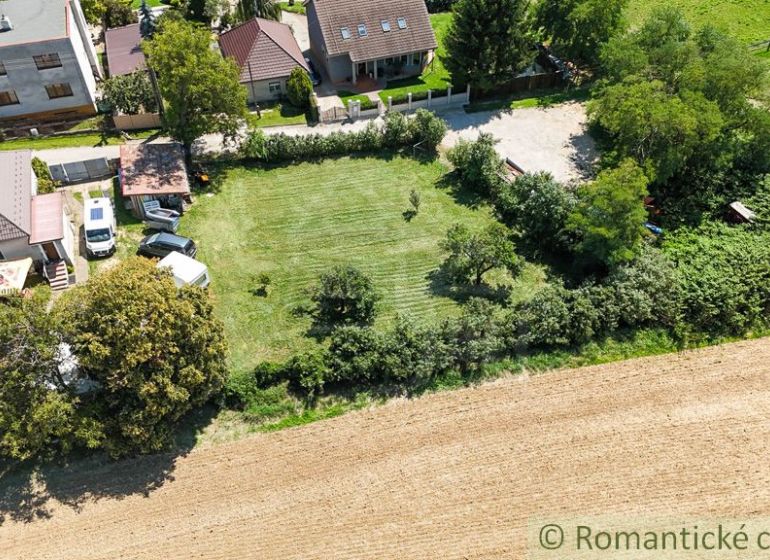 Házak kertekkel Pastuchovban, mező és zöldövezet veszi őket körül.