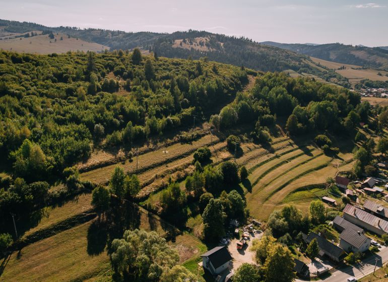 Légi felvétel a zöld dombokról és házakról a Čierny Balog-i Školská utcában.