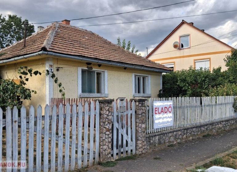 Családi ház Tornyosnémetiben téglatetővel és színes kerítéssel.