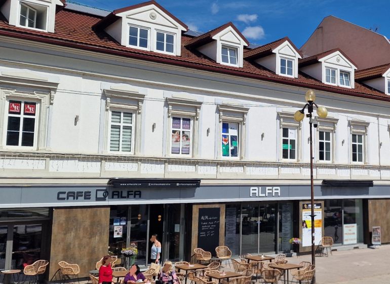 Épület kávézóval és terasszal a Szent Egid térnél Poprádon, irodák az emeleten.