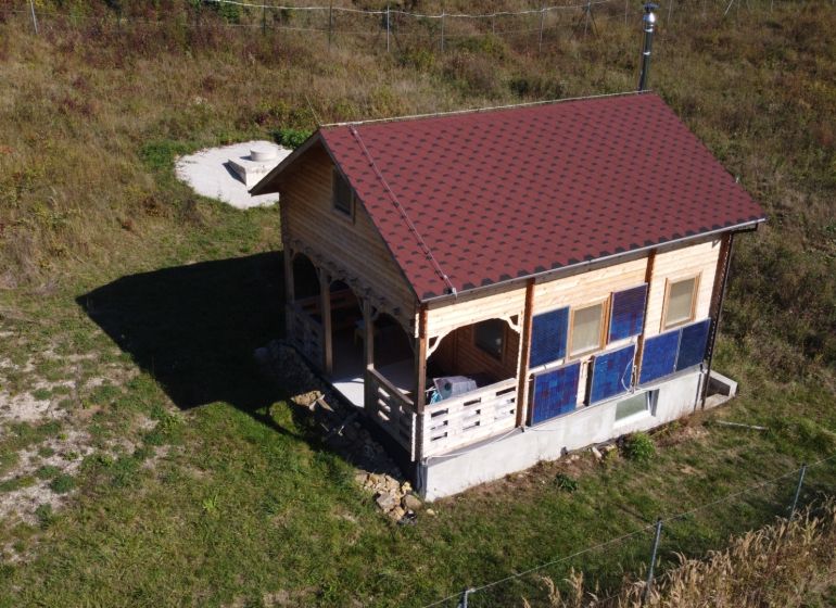 Faház Horná Breznicában fa burkolattal és piros tetővel a zöld telken.
