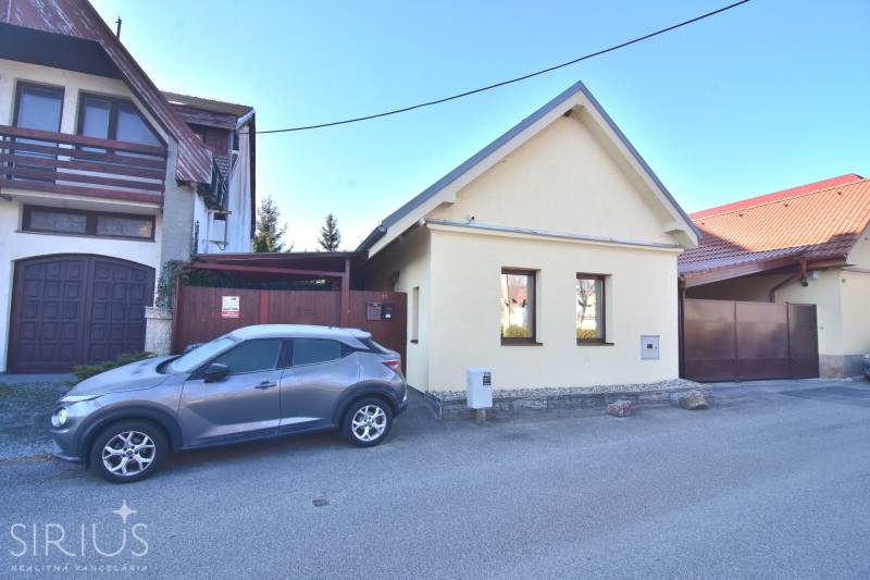 Rodinný dom a zaparkované auto na ulici Limbach, pokojná mestská lokalita.