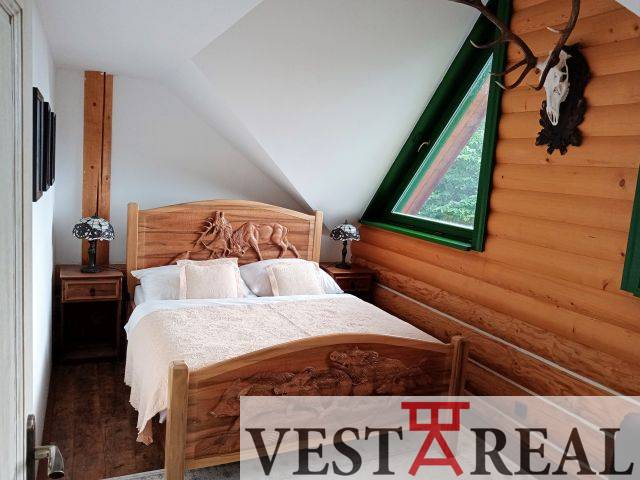 Spálňa v drevenej chate s postele z masívu a šikmé okno, Vestareal.
