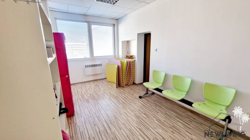 Jasná kancelária s podlahou, zelené stoličky, na ulici Teplická, svetlo z veľkého okna.