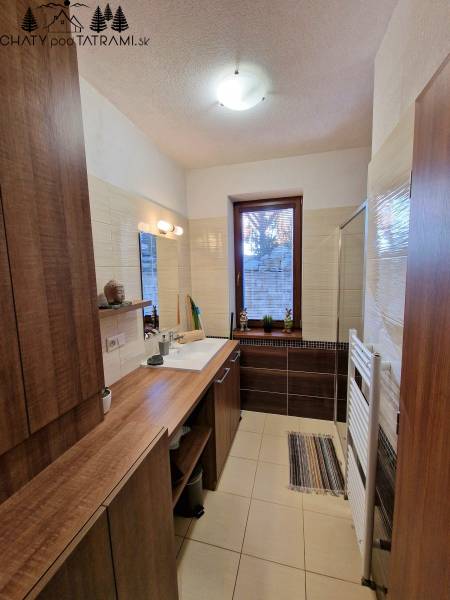 Kúpeľňa v rekreačnom apartmáne na ulici Trangoška, zariadená dreveným nábytkom a doplnkami.