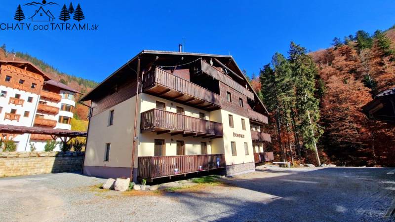 Na obrázku je budova so zábradlím, lesom, na ulici Trangoška, pri rekreačnom apartmáne.
