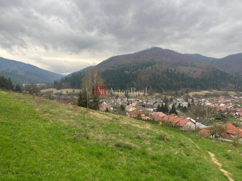 Výhľad na Kokavu nad Rimavicou, obklopenú prírodou s malebnými rekreačnými pozemkami a kopcami.