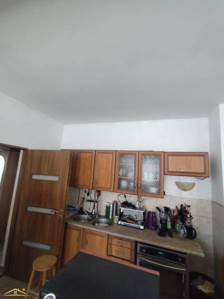 Kuchyňa v rodinnom dome na ulici Oščadnica s drevenými skrinkami a spotrebičmi.