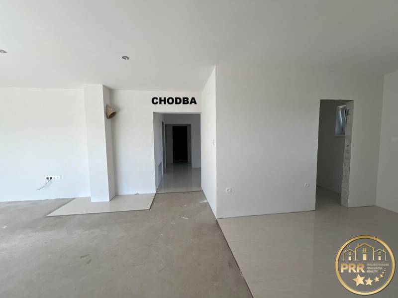 Interiér rodinného domu s priestrannou chodbou a svetlými stenami, vyvoláva útulnosť.