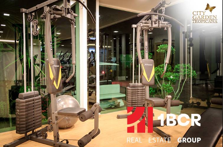 Fitnesz felszerelés a lakások építésében, zöld elemek, világítás és tükrös falak.