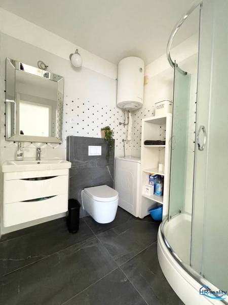 Fürdőszoba a nyaraló apartmanban WC-vel, zuhanyzóval, mosdóval és bojlerrel.