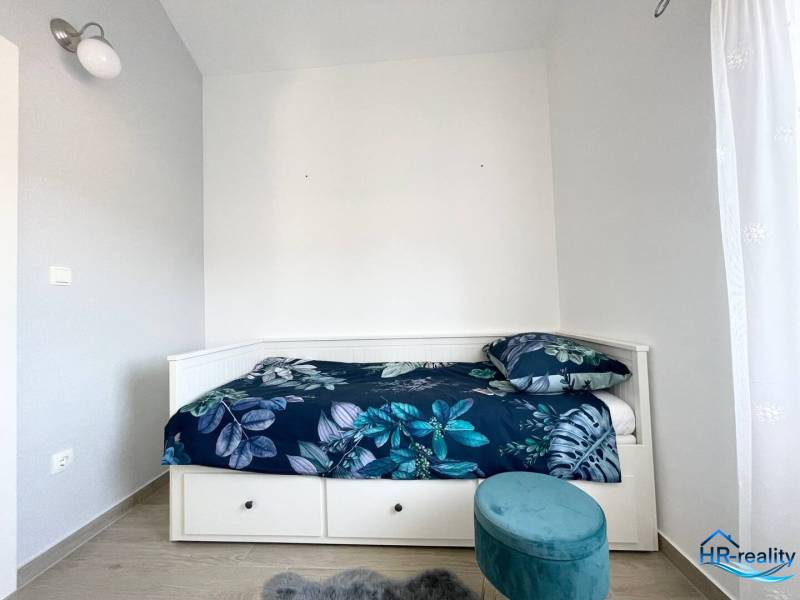 Nyaraló apartman ággyal és kék mintás ágyneművel.